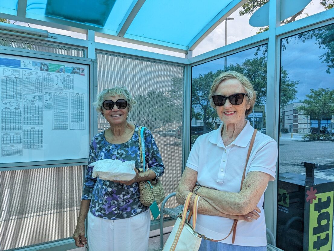 Two female seniors waiting at a PSTA bus shelter
