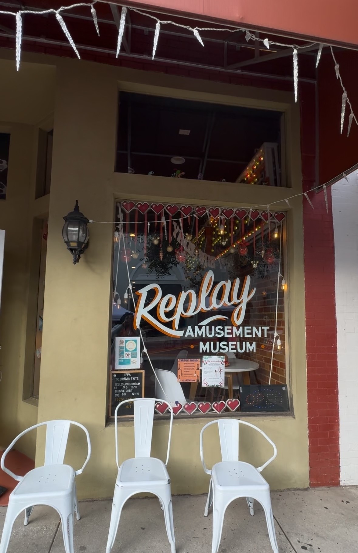 A photo of the outside of Replay Amusement Museum. The logo is on the window display.