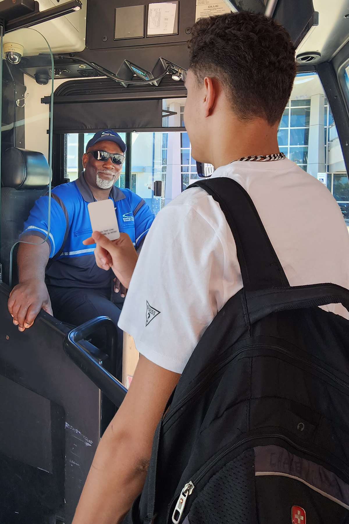 A student shows their school ID to a bus operator so they can ride free with the UPASS program