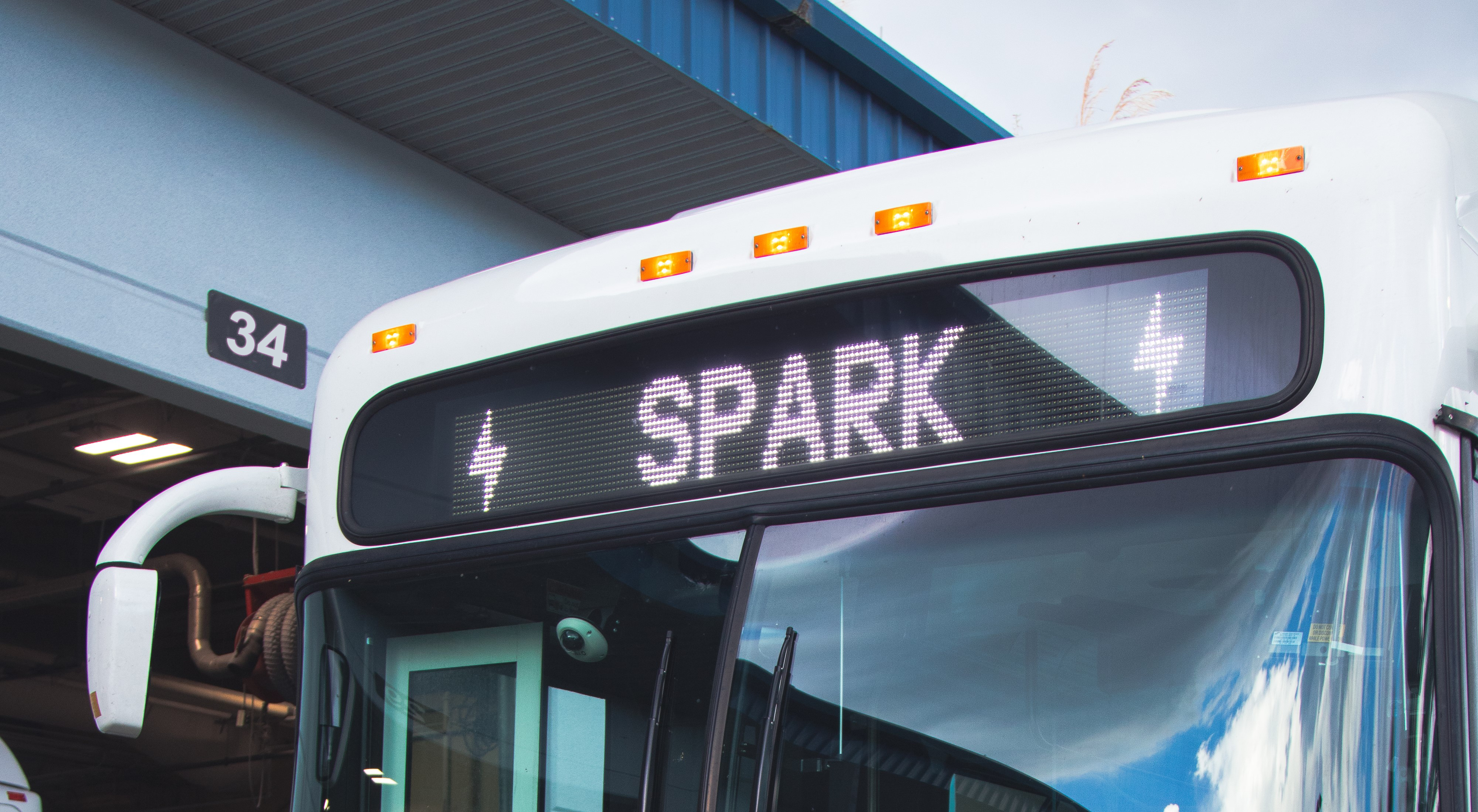 A photo of the front of a Spark bus, showing lightning bolts and "SPARK" on the headsign