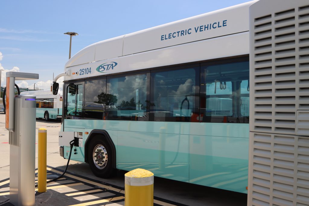 A photo of a PSTA electric bus charging in the bus yard. 